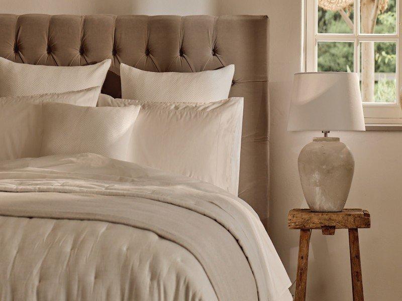 close up of a white bed with pillows on it