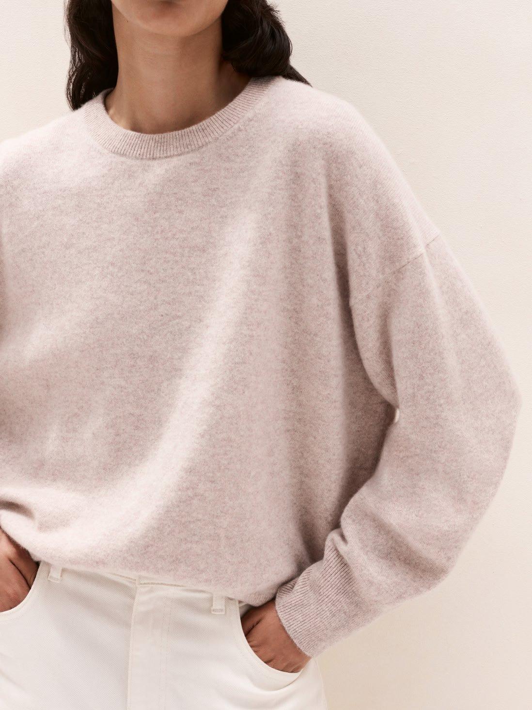 a woman in white pants and a light pink sweater
