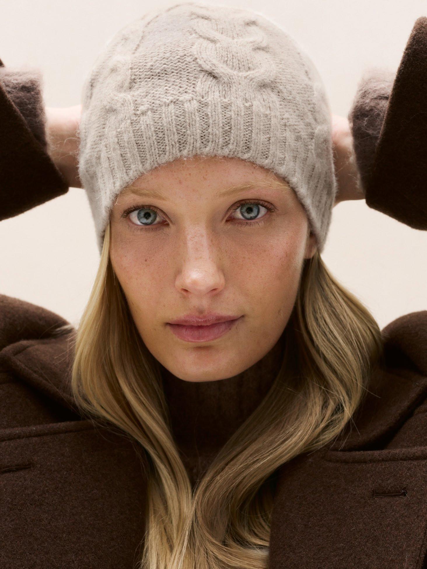 a woman with a hat on her head and a jacket on