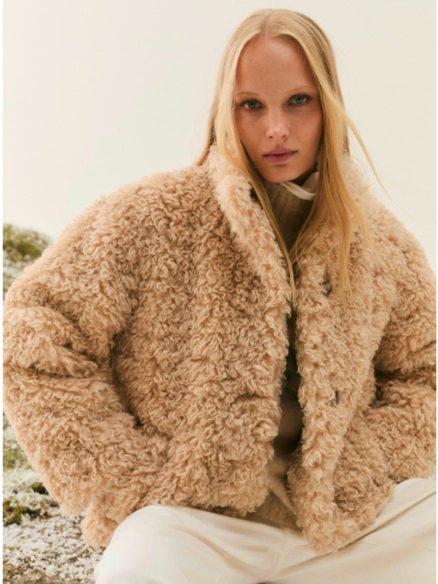 a woman in a furry jacket posing for a photo shoot