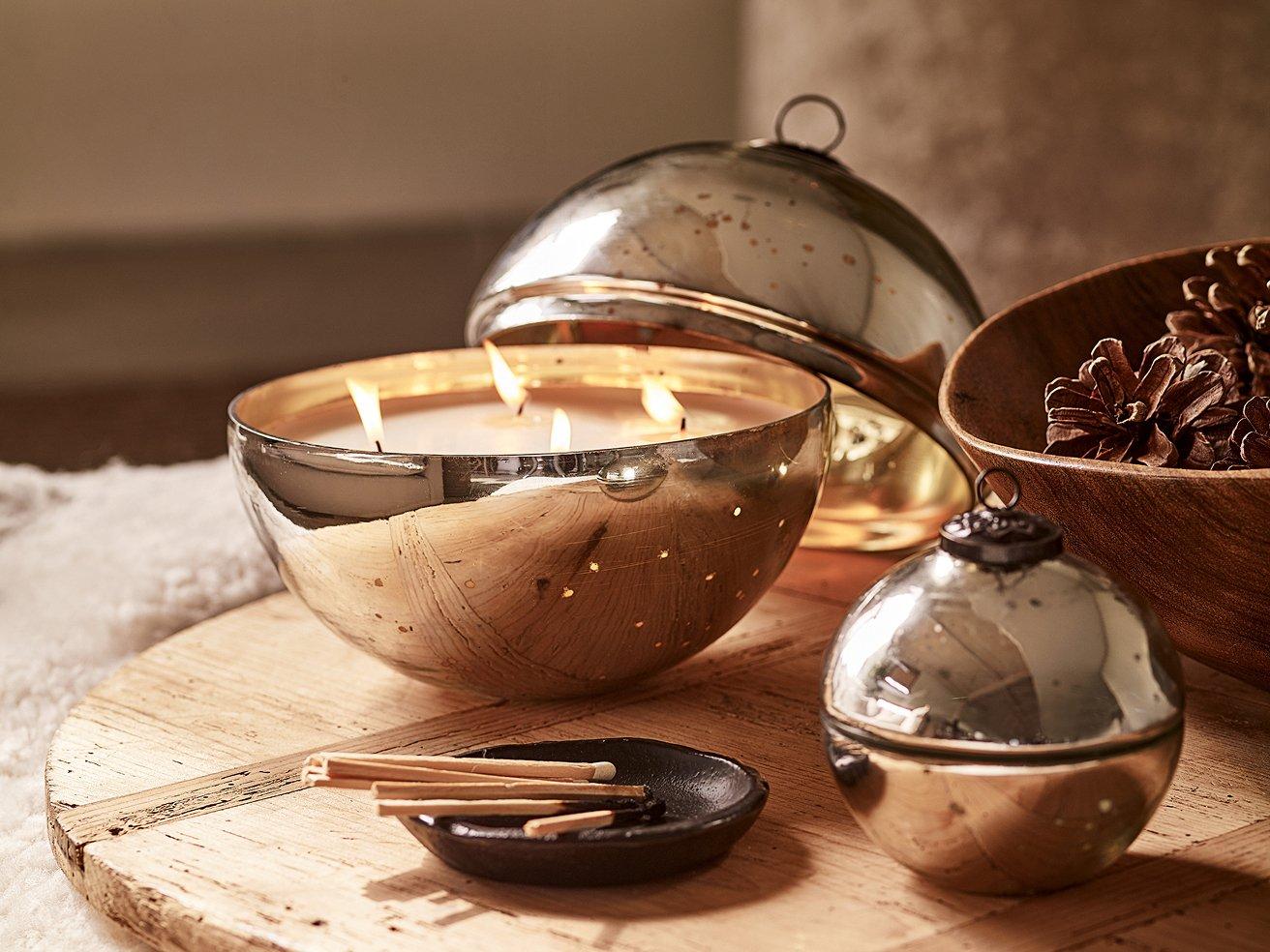 a candle sitting on a wooden table next to a vase of flowers