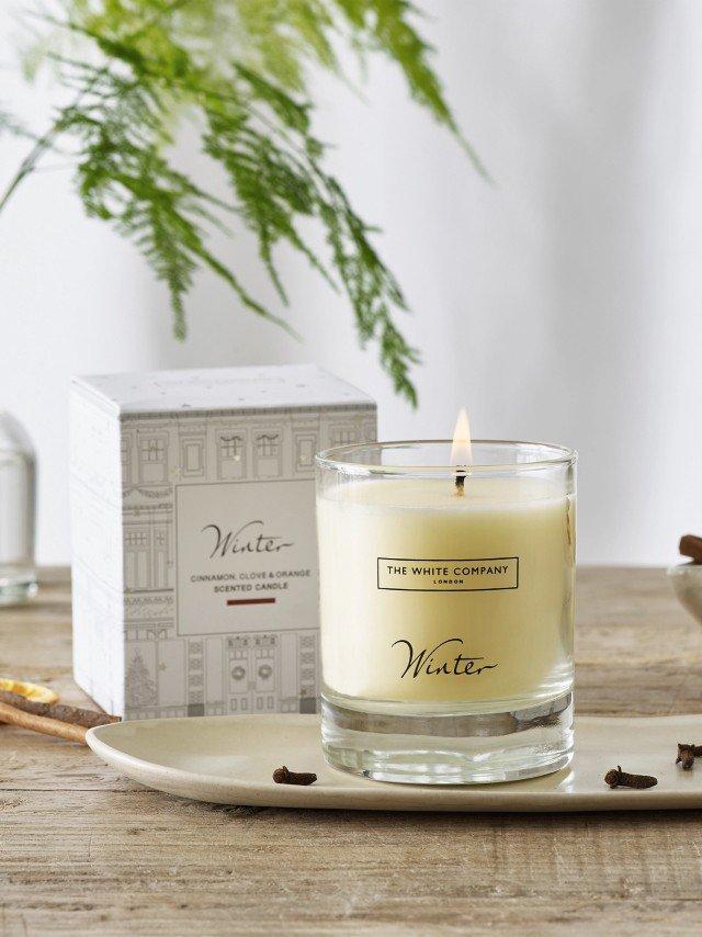 a candle sitting on a plate next to a box of spices