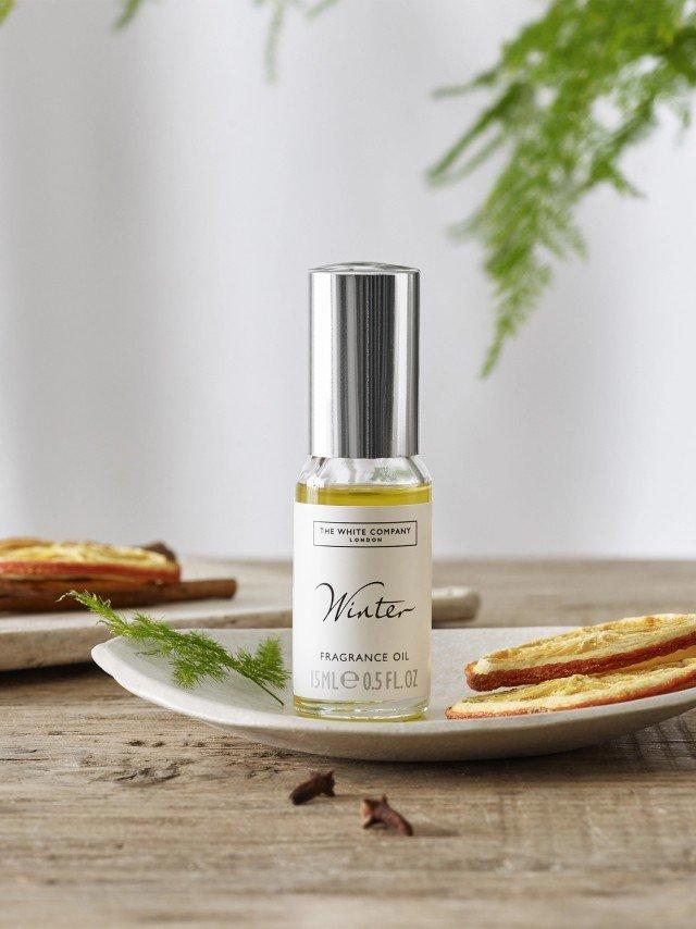 a plate with a bottle of perfume and some apple slices