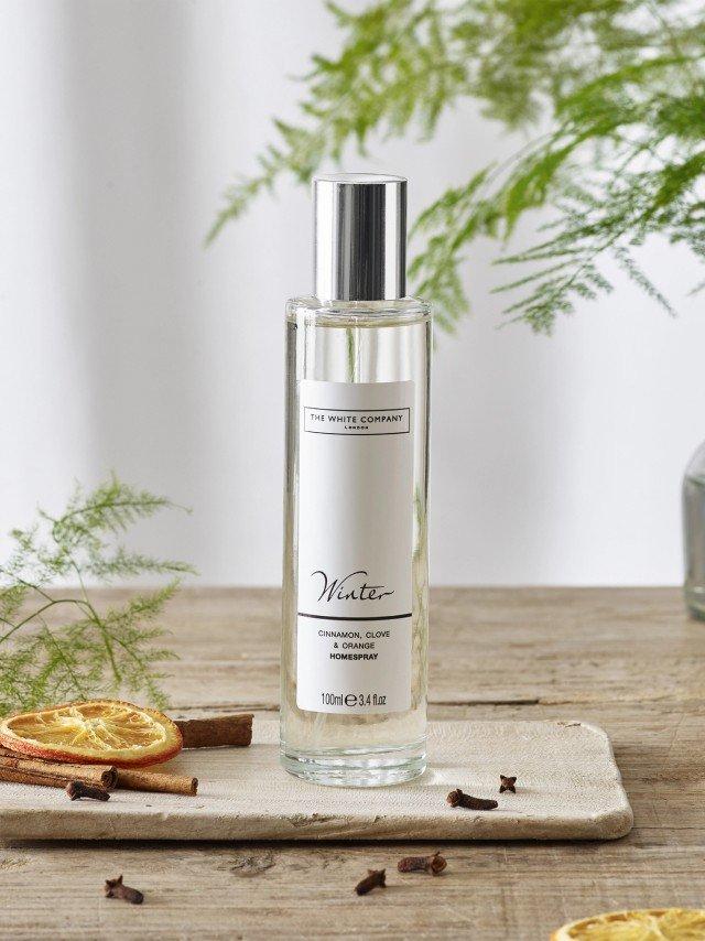 a bottle of perfume sitting on a table next to some sliced oranges