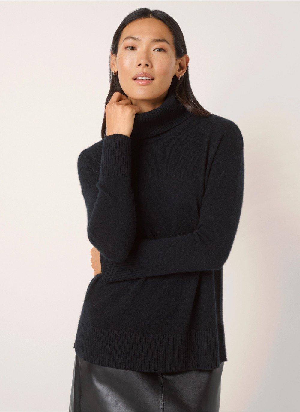 a woman in a black turtle neck sweater and black skirt