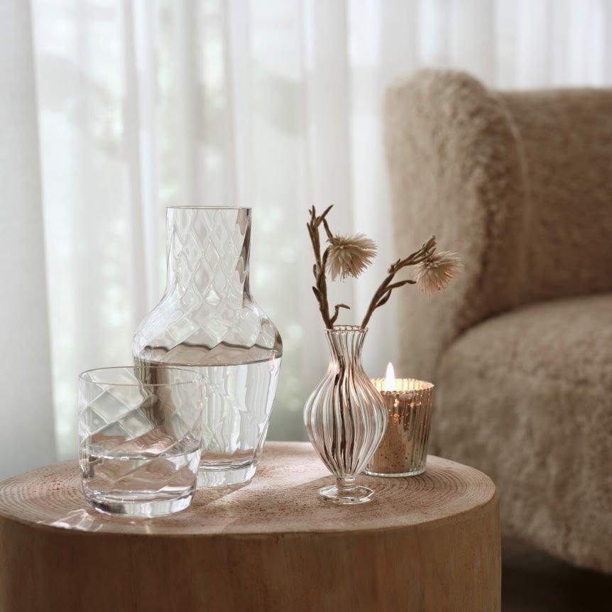 a small table with a vase and a candle on it