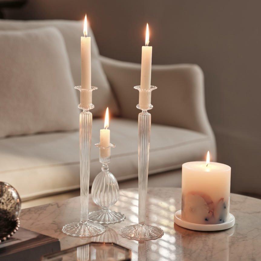three candles sit on a table next to a small white candle