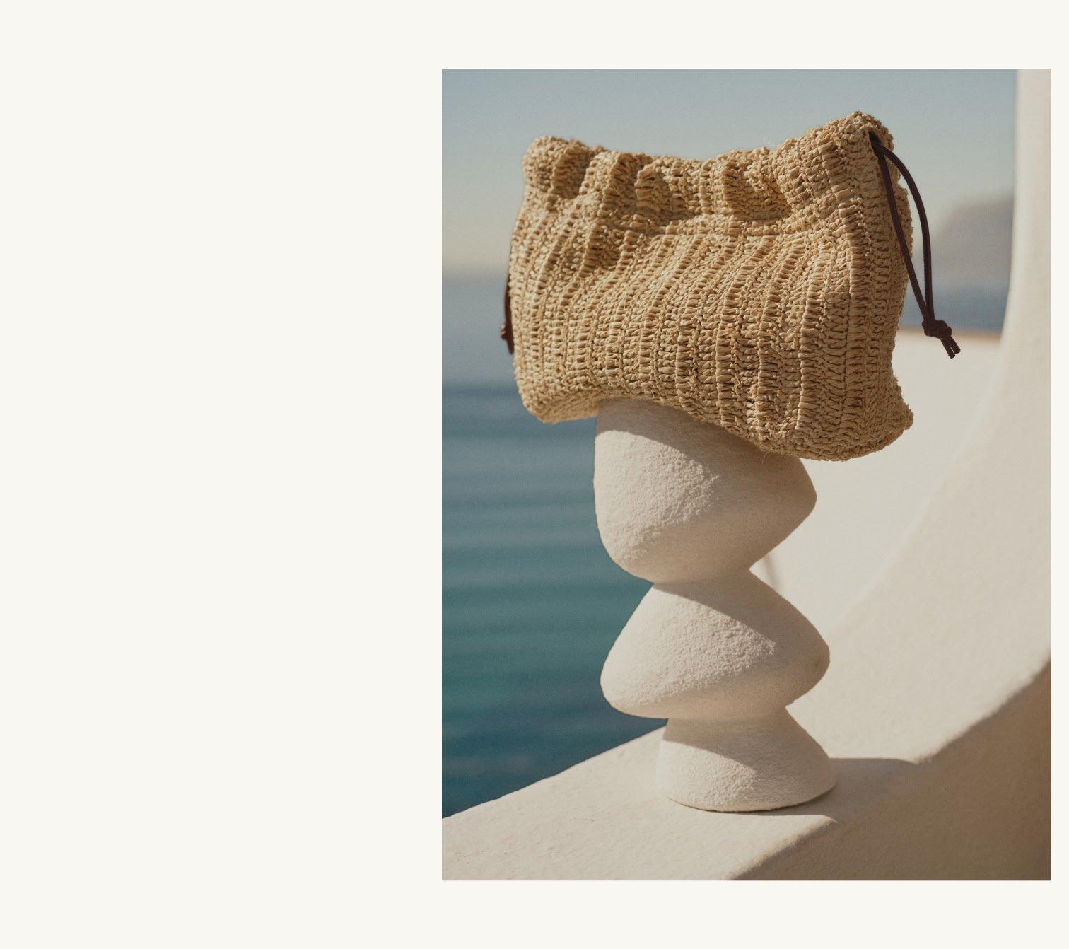 a bag sitting on top of a stone pillar on the beach