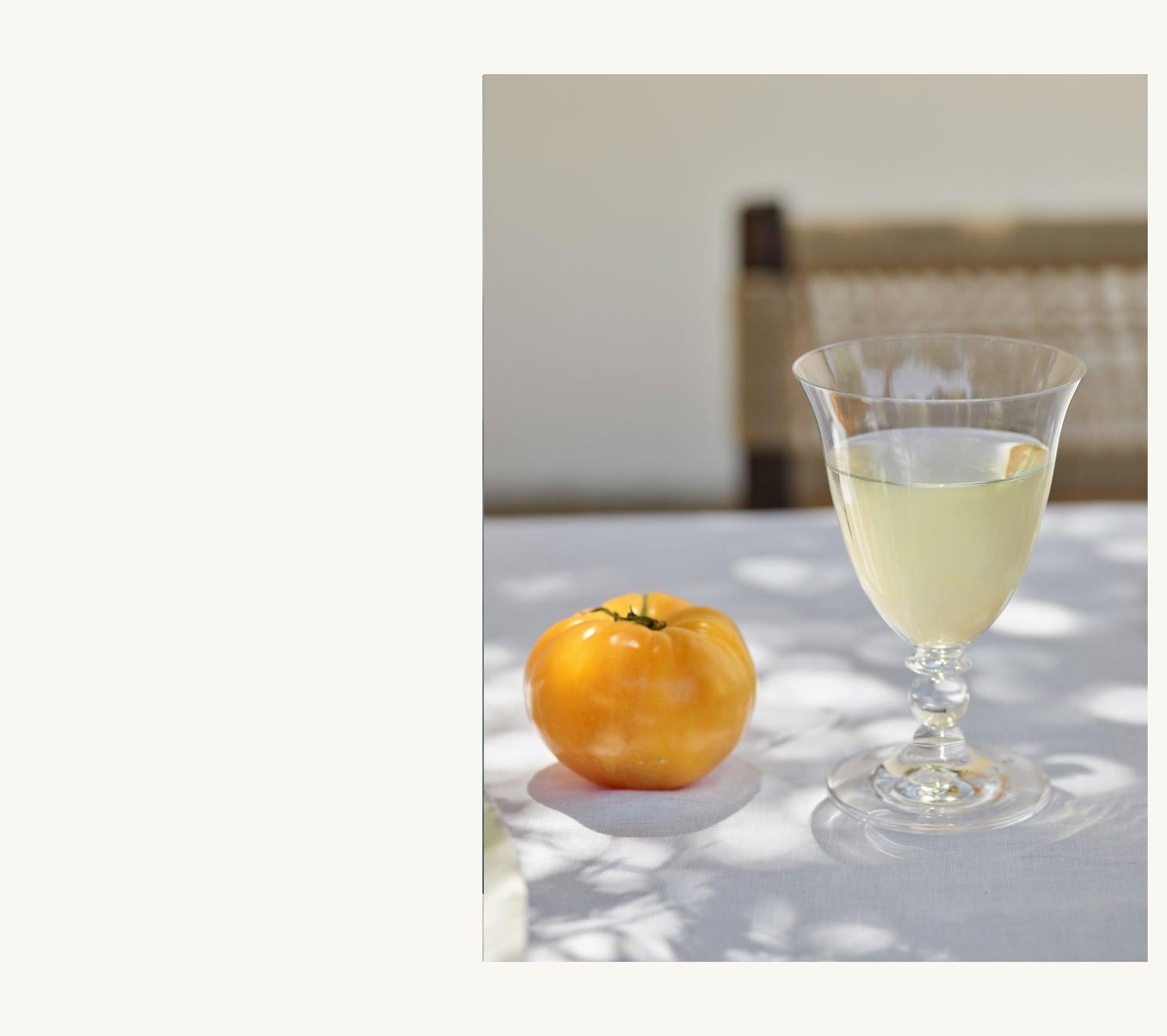 a glass of wine and an orange on a table