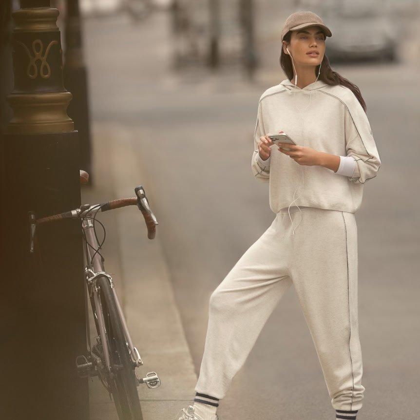 a woman in a white outfit standing on a street corner