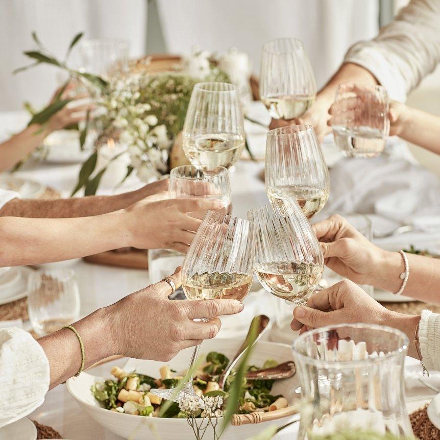 a group of people toasting glasses of wine at a dinner table