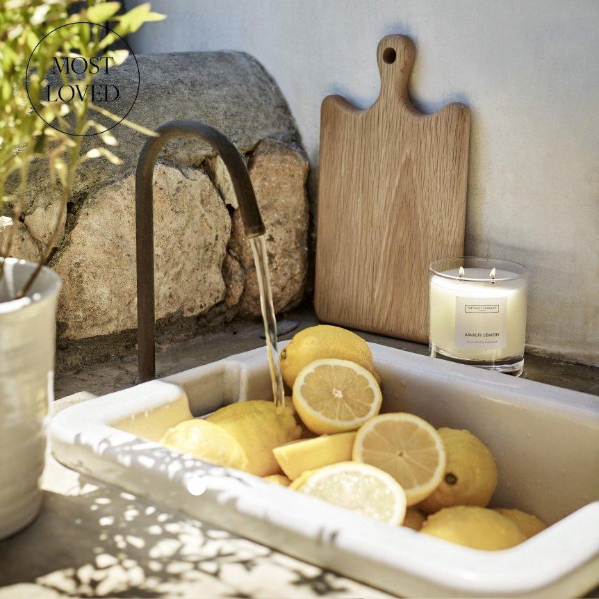 a sink filled with lemons and a candle next to it