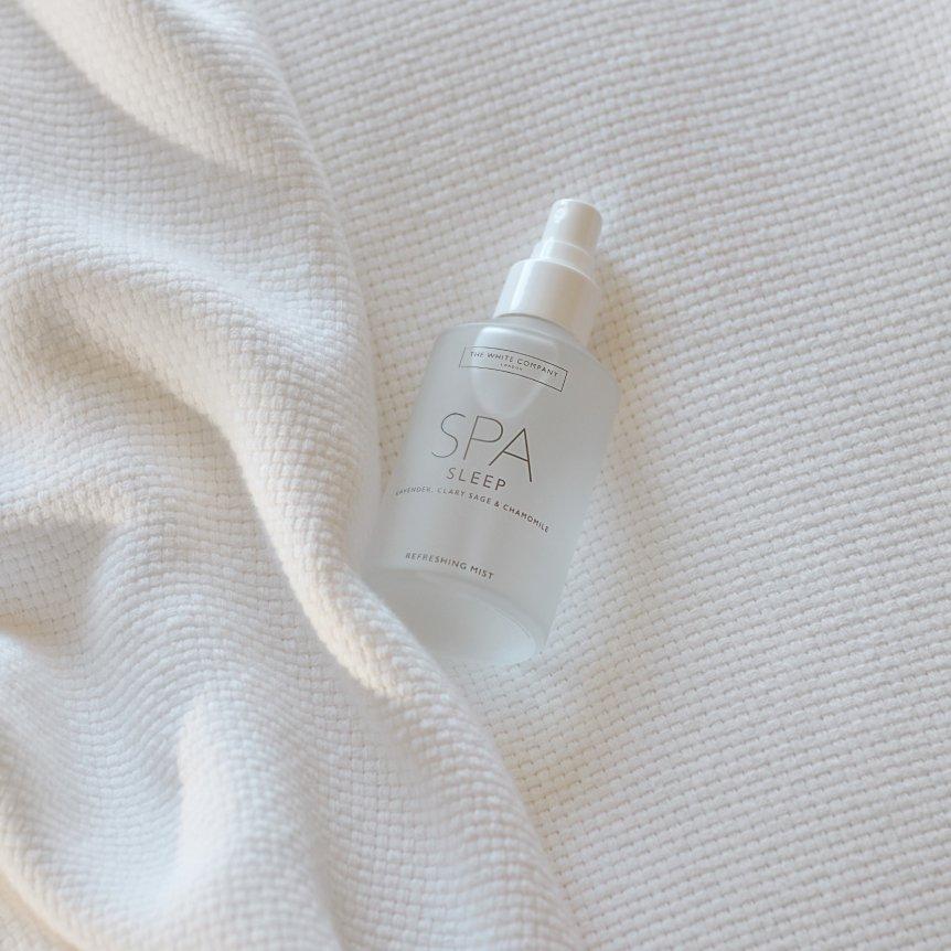 a bottle of spa sleep spray on a white blanket