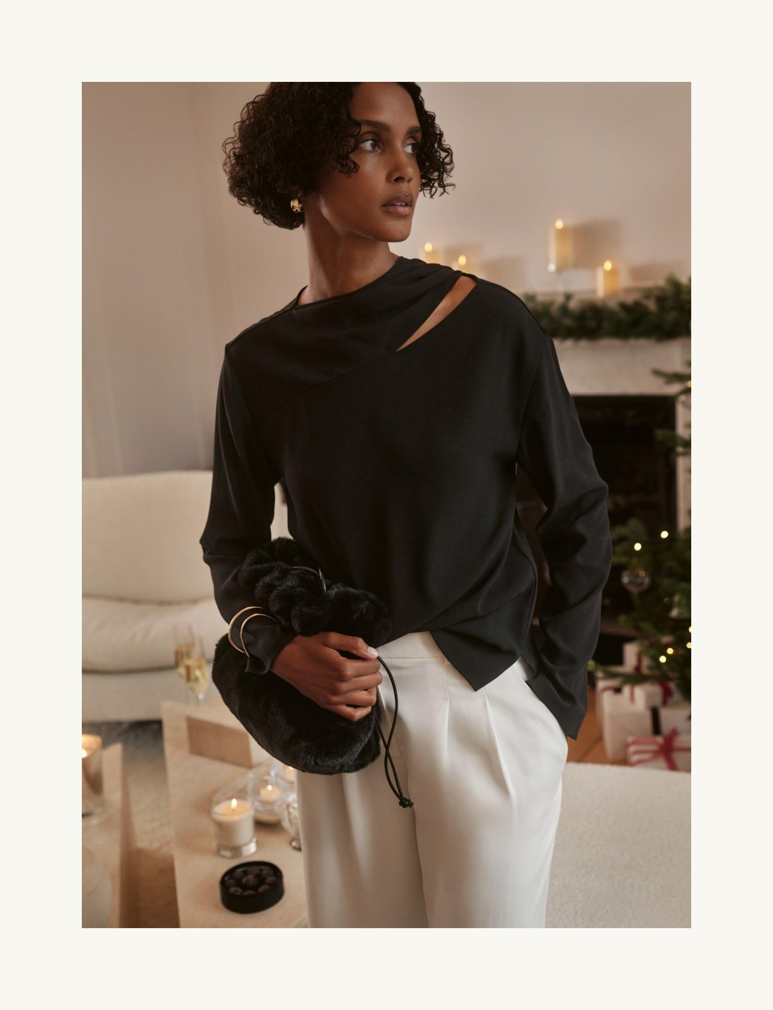a white teapot and cup on a table with a plate of cookies