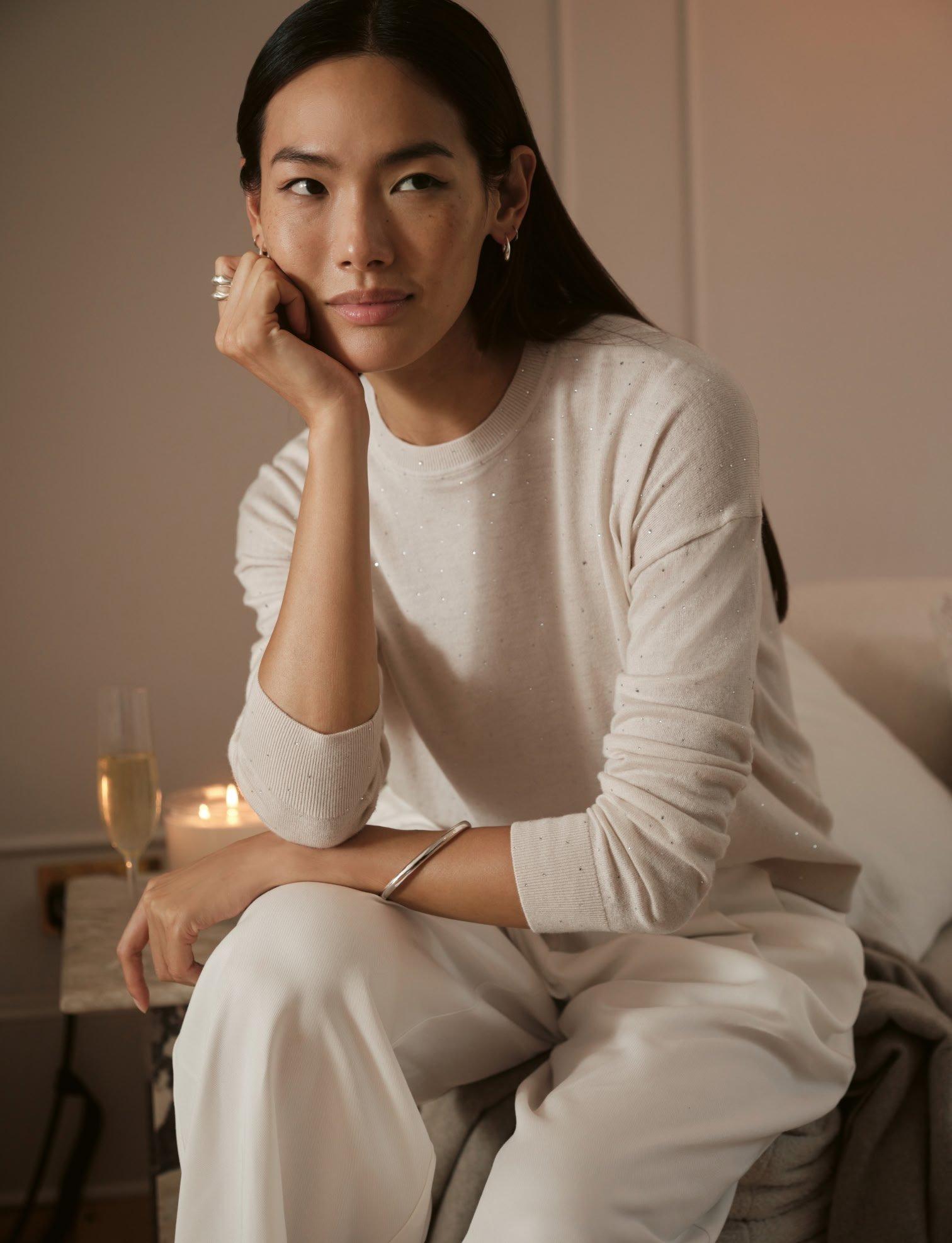 a white teapot and cup on a table with a plate of cookies