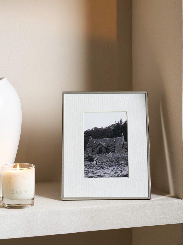 a picture of a picture frame and a candle on a shelf