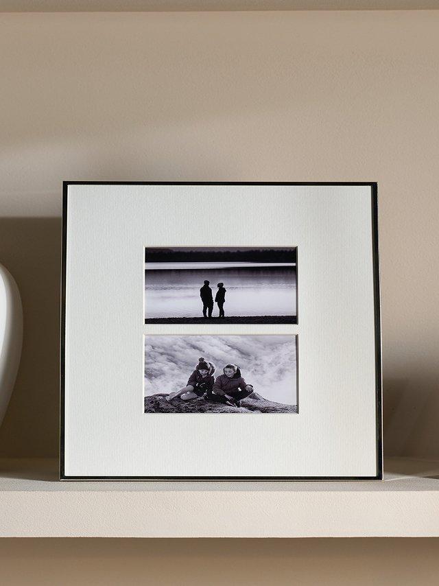 a shelf with two picture frames on it and a vase