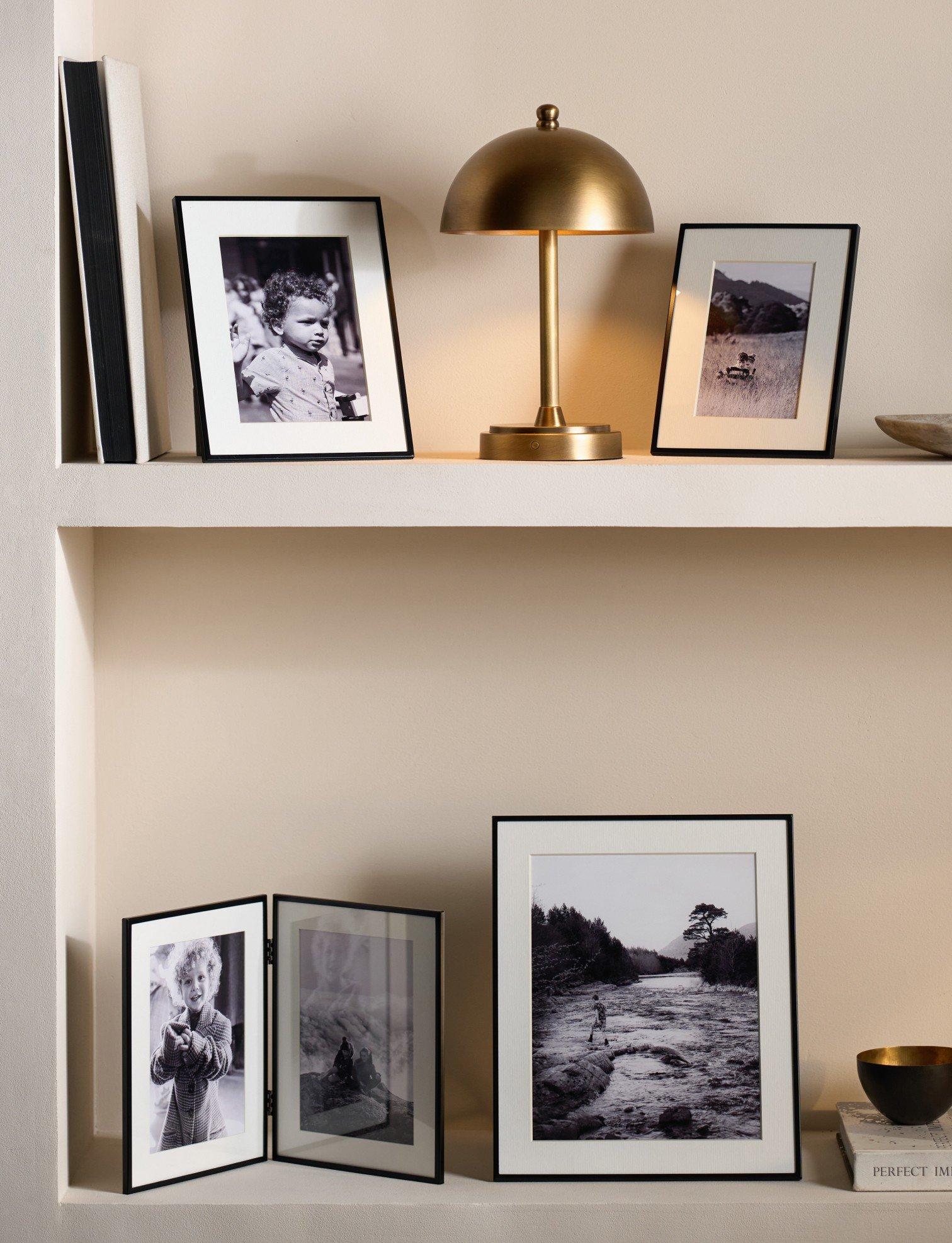 a shelf with a lamp, a picture frame and a lamp shade