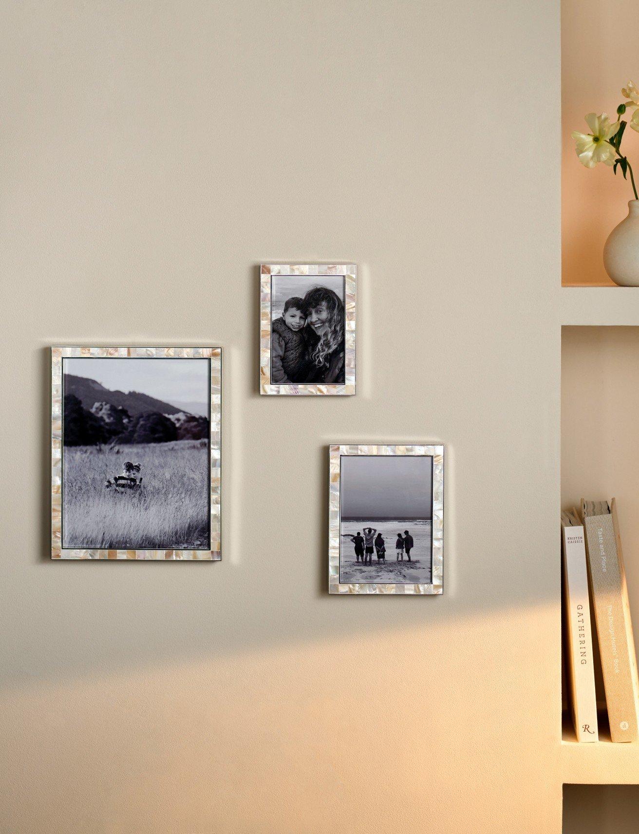 a wall mounted pictures of flowers and a vase on a shelf