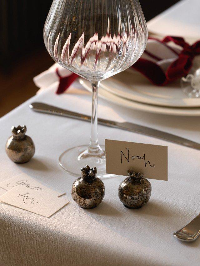a wine glass with a place card on a table with silverware
