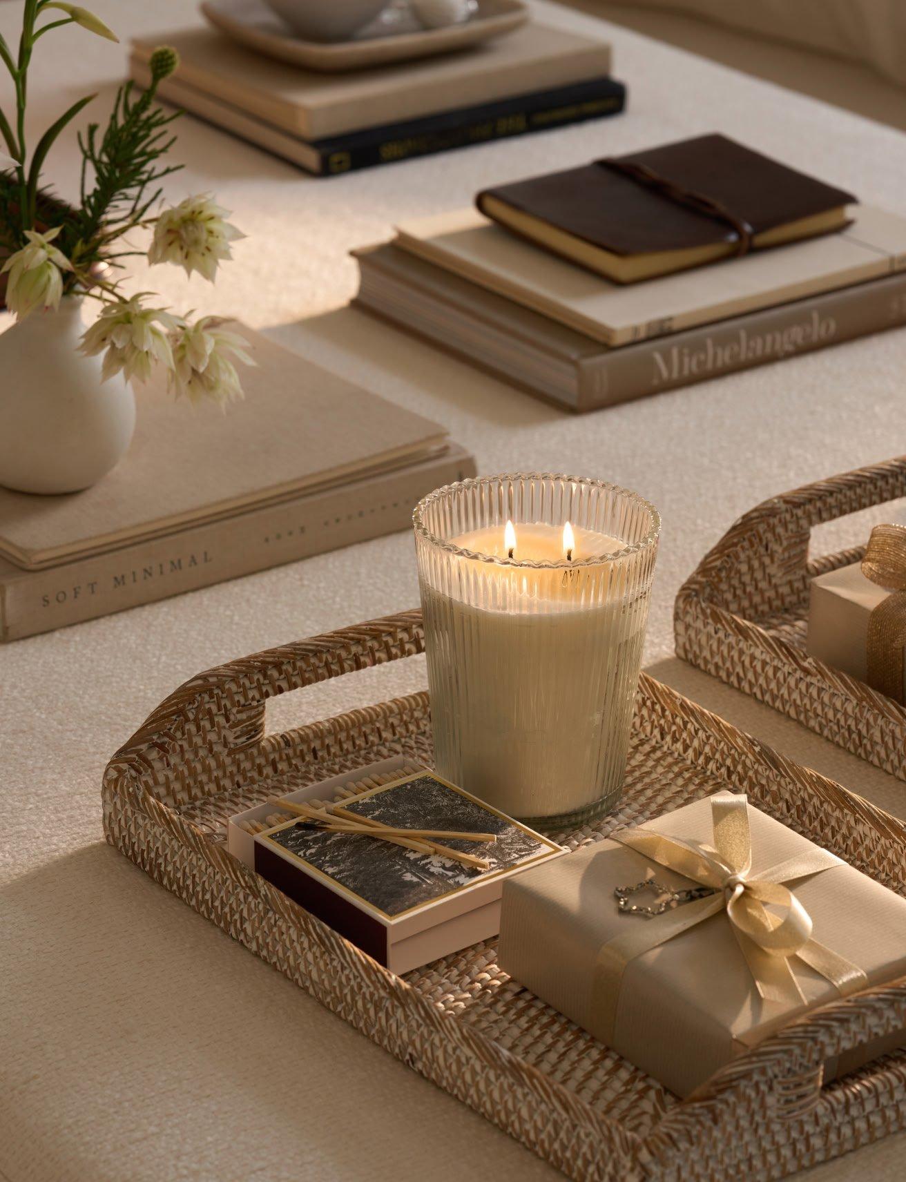 a table with a tray of books and candles on it
