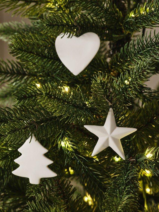 a close up of a christmas tree with white ornaments and a heart
