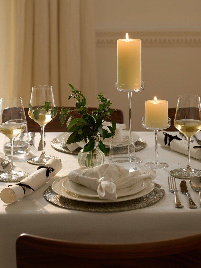 a table set for a dinner with candles and wine glasses