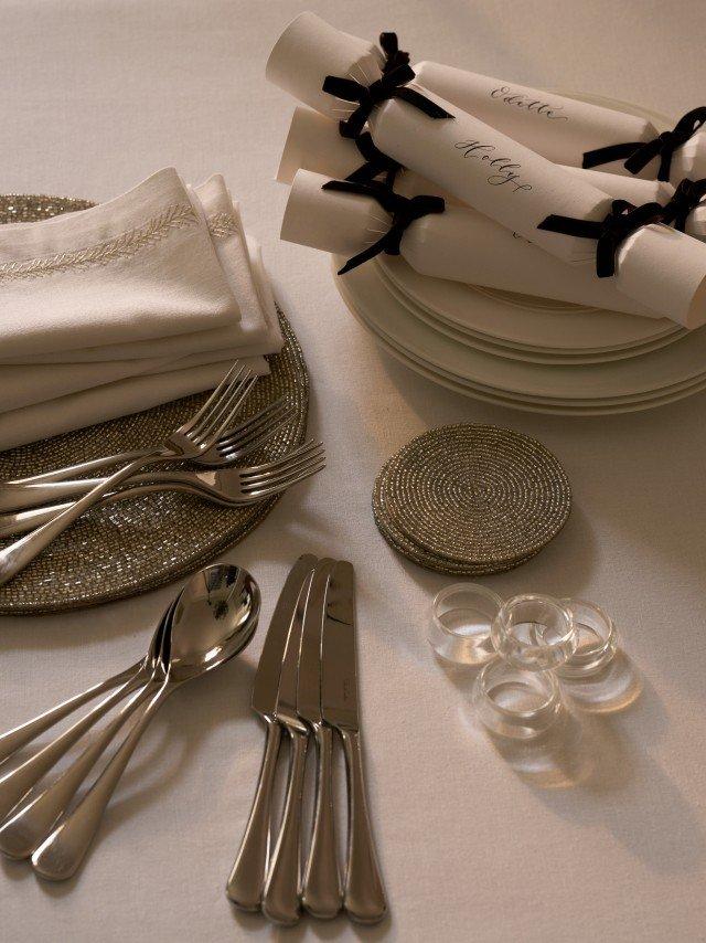 a table setting with silverware and napkins on a white tablecloth