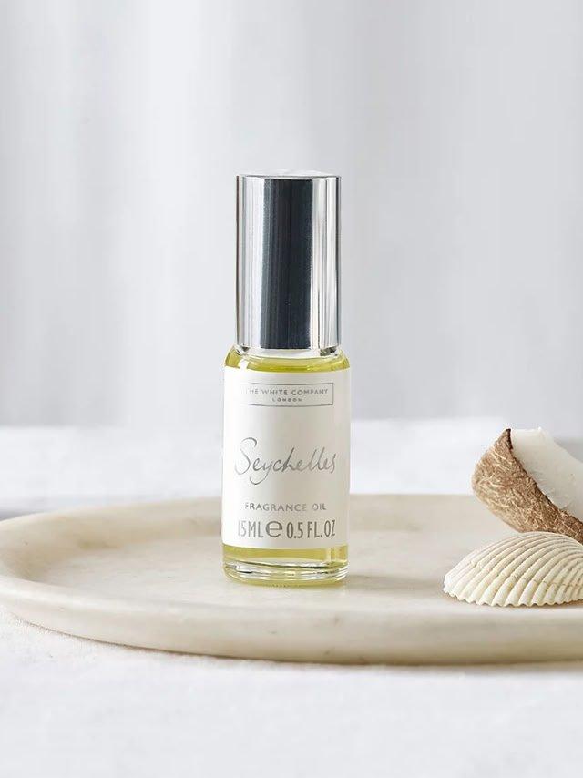 a bottle of a perfume sitting on a plate next to a shell