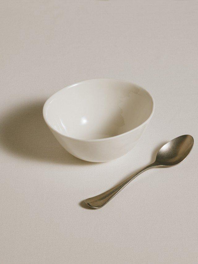 a spoon and a bowl on a table with a yellow dot