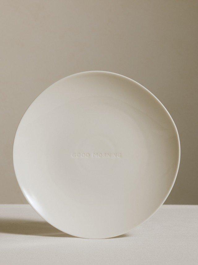a white plate with a yellow ball on top of it