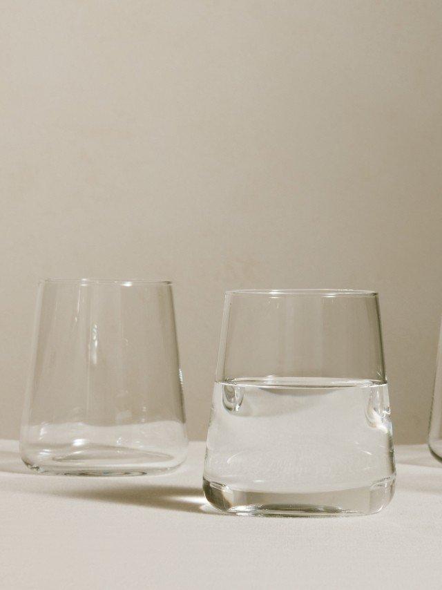 a close up of a glass of water with a tennis ball in it