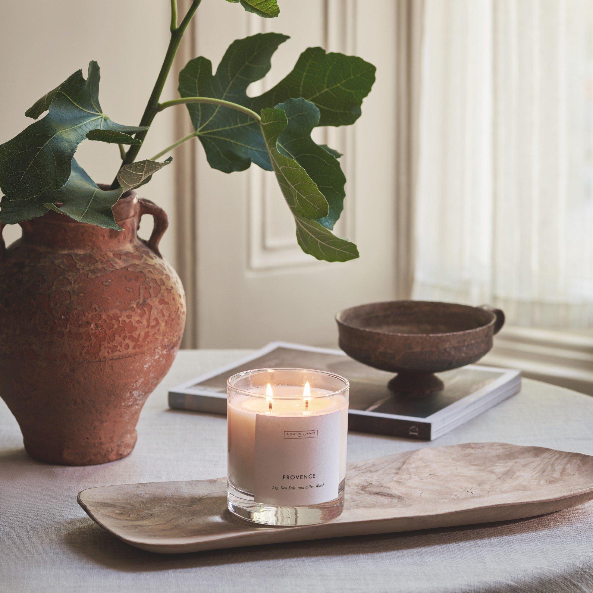 a candle on a table next to a vase of flowers