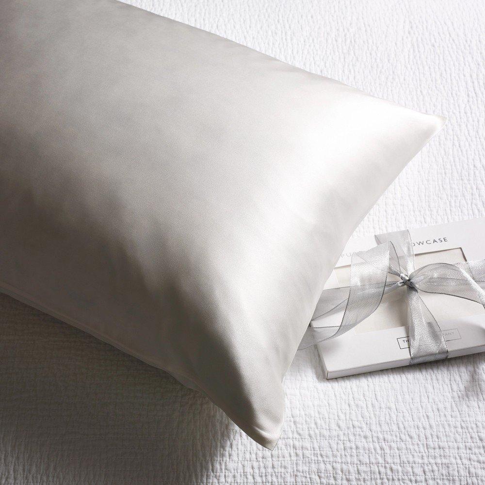 a pillow with a ribbon tied around it sitting on a bed