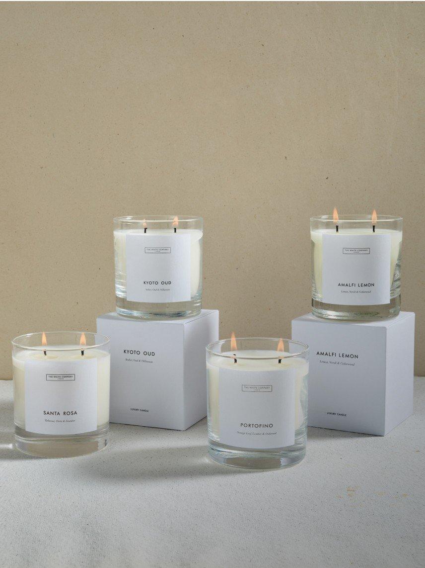 three candles are sitting on top of white boxes with labels