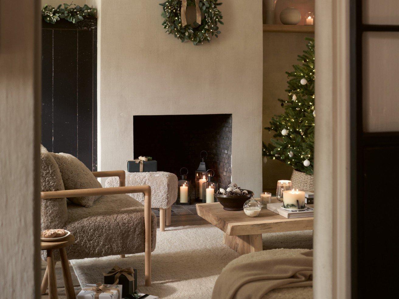 a living room with a fireplace and christmas tree in the corner
