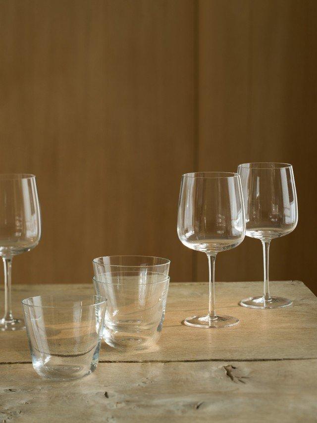 a table with four empty wine glasses and one empty glass