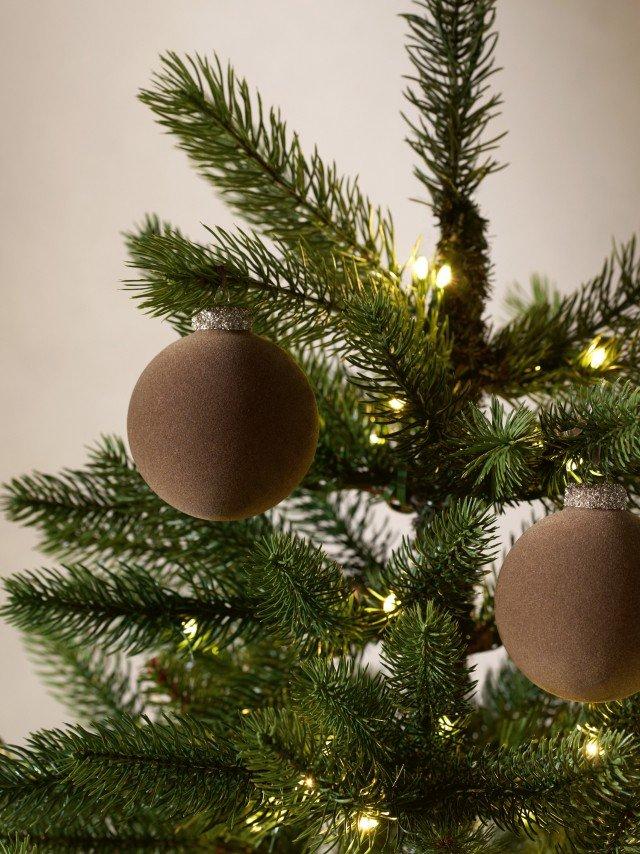 a close up of a christmas tree with two ornaments on it