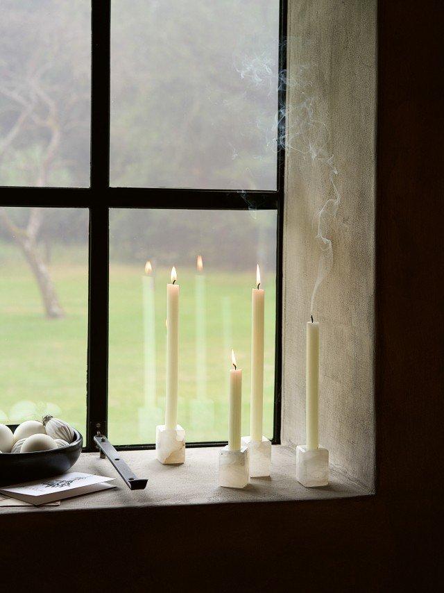 a window sill with candles and bowls of food on it
