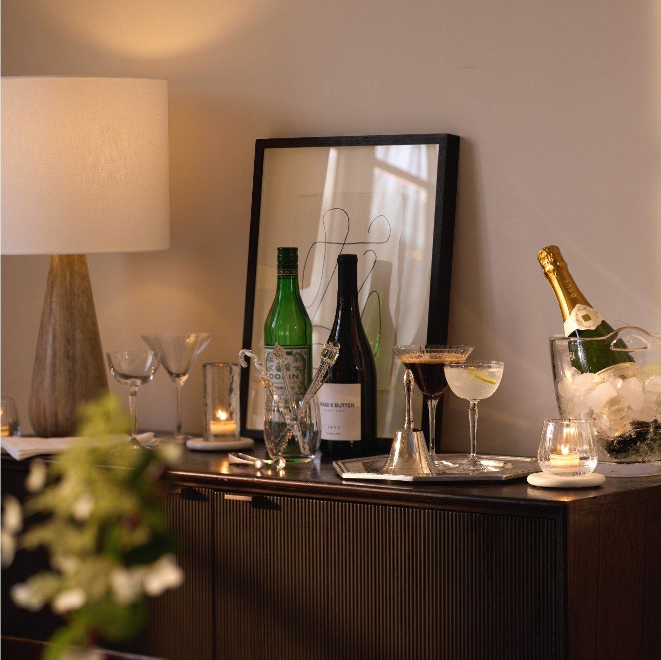 a table with a vase, wine glasses, and a bottle of wine