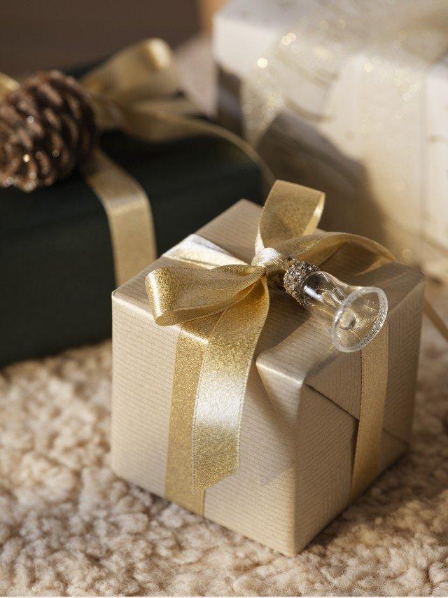 two wrapped presents sitting on a carpet with a bow on top