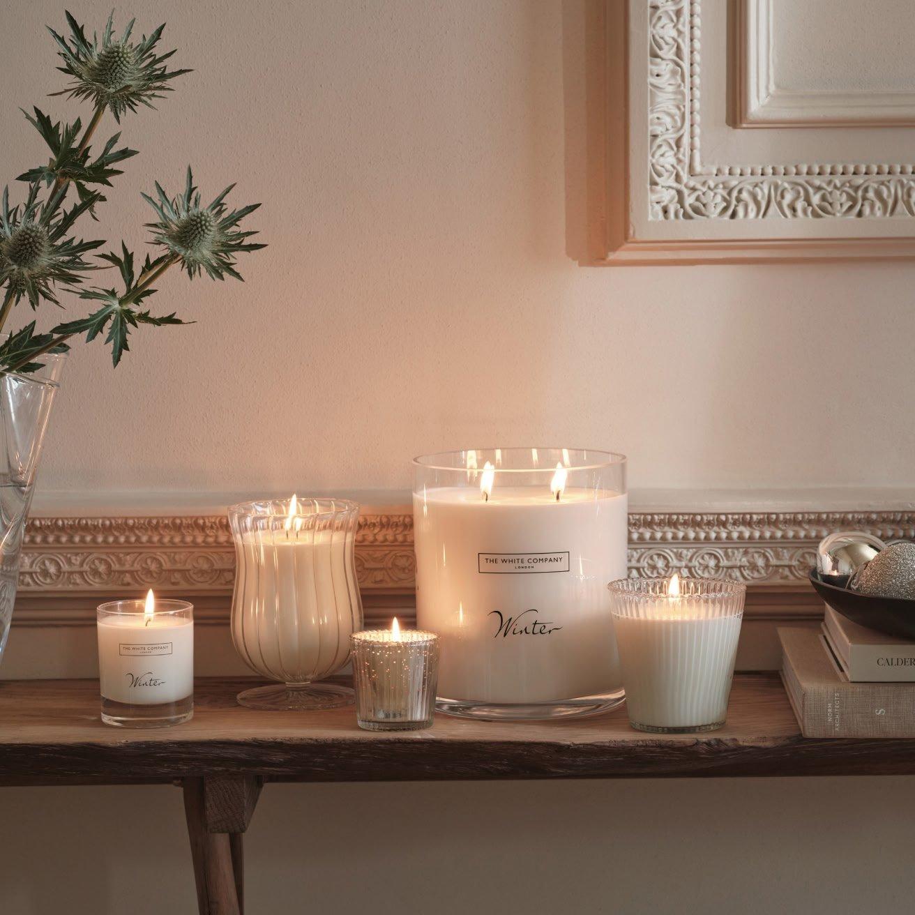 a table with candles and a plant on it in a room
