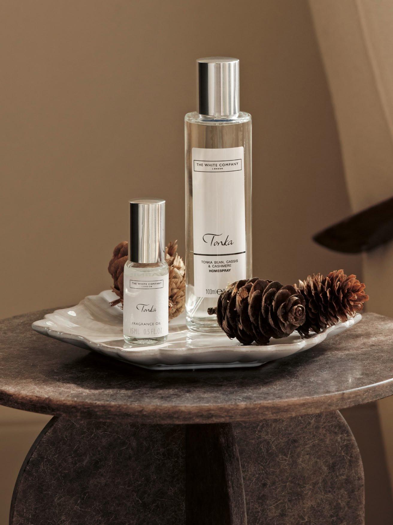 a table with two bottles of perfume and a pine cone