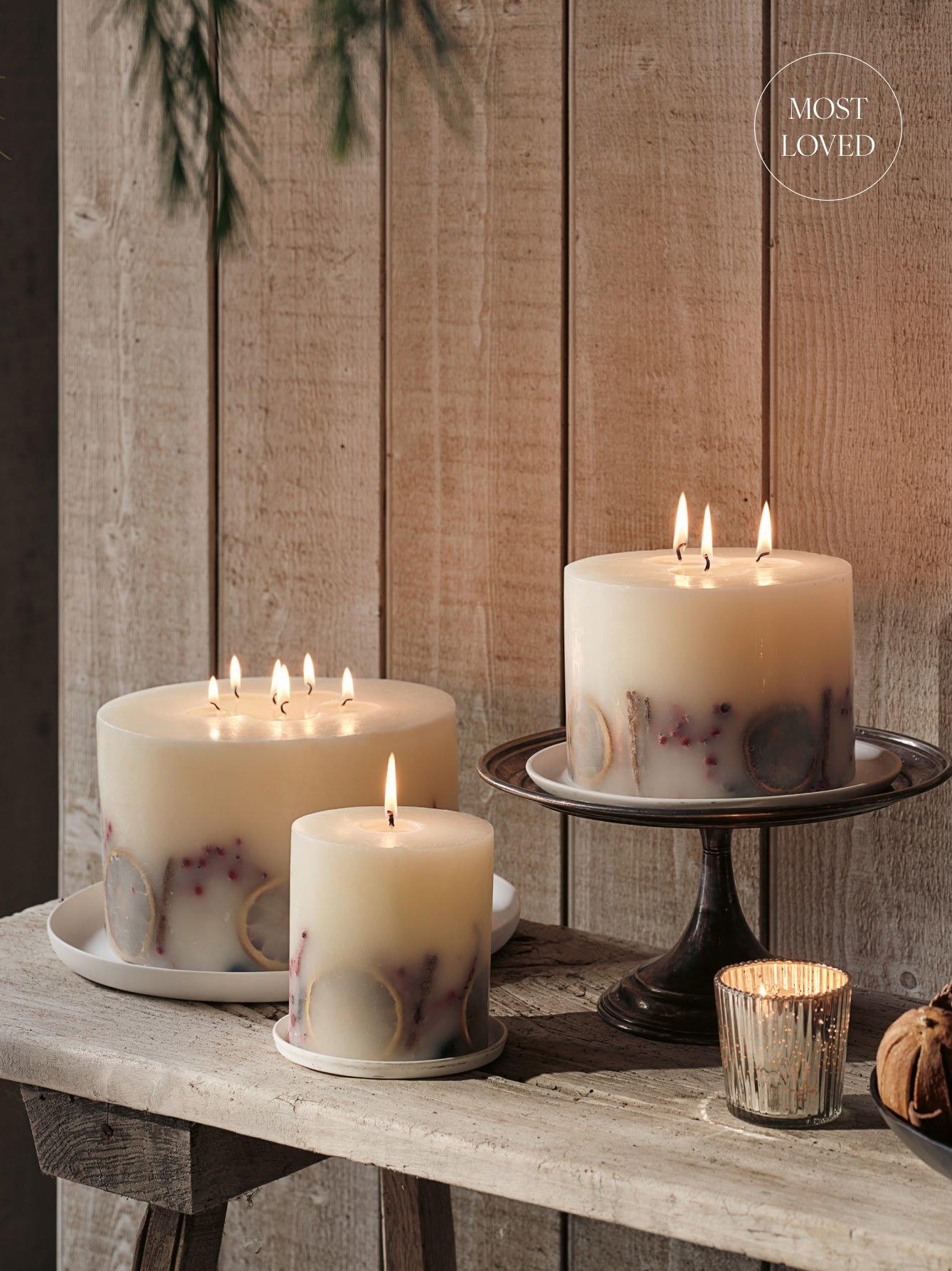 a table with three candles on it and a candle holder