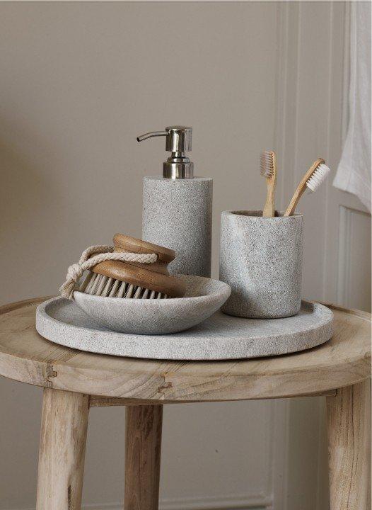 a bathroom accessories on a wooden tray on a table