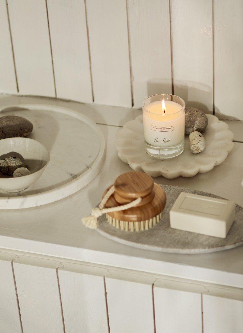 a candle, soap, and other items are on a counter