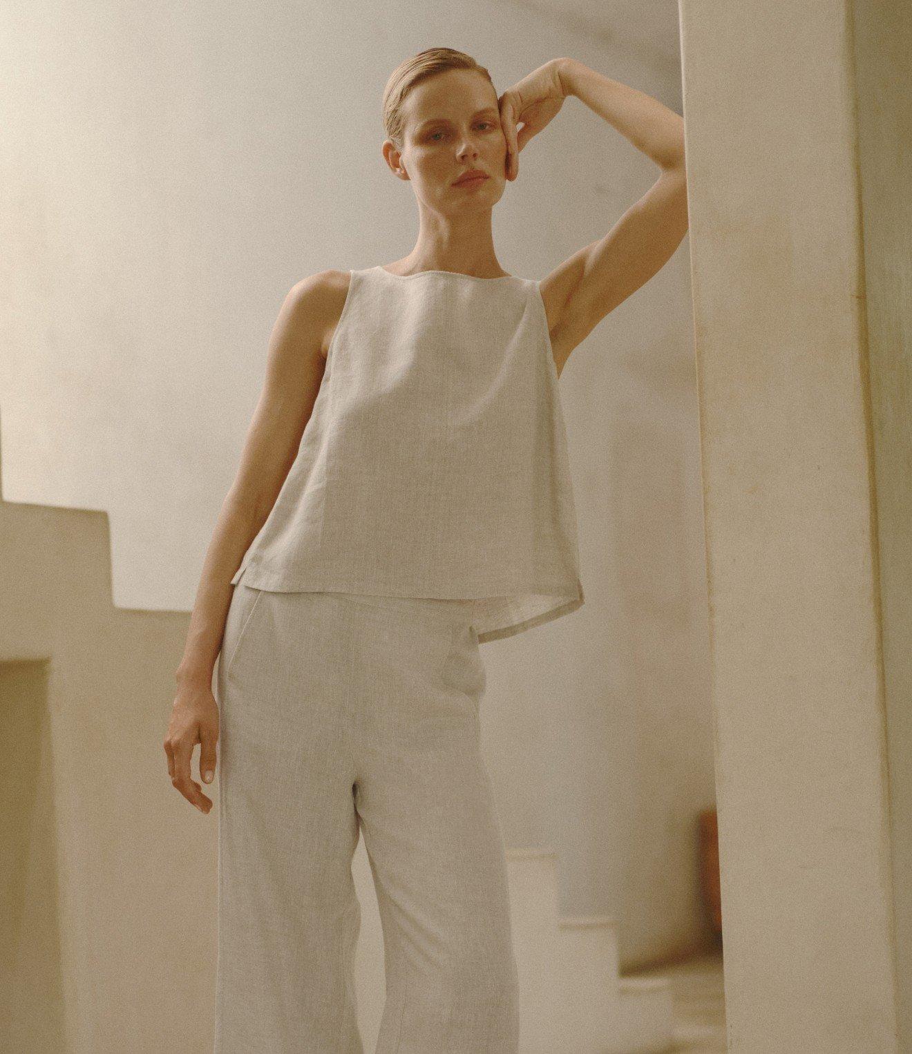 a woman in a white dress posing for a picture