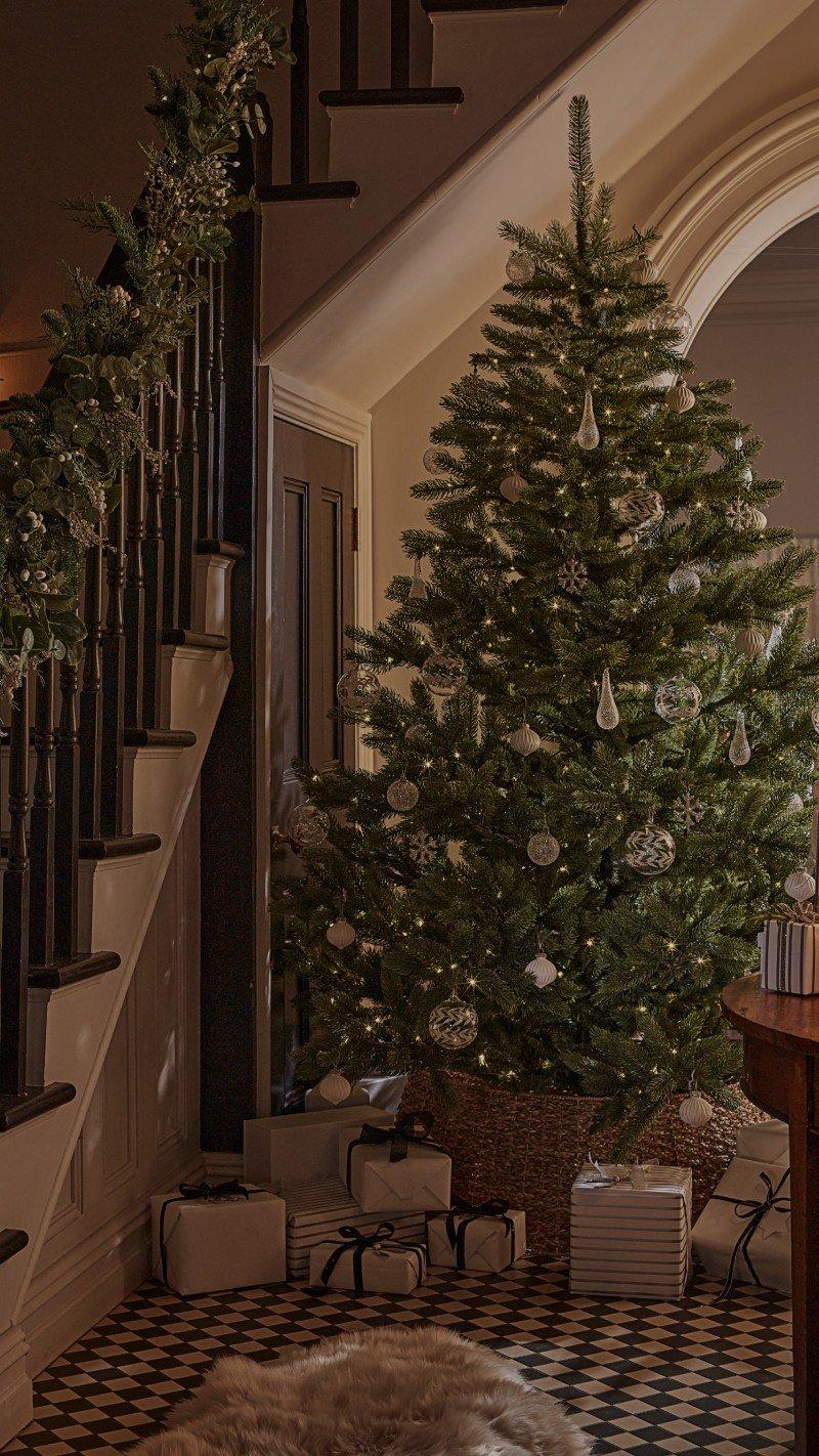 a christmas tree is displayed in a stairwell with a staircase