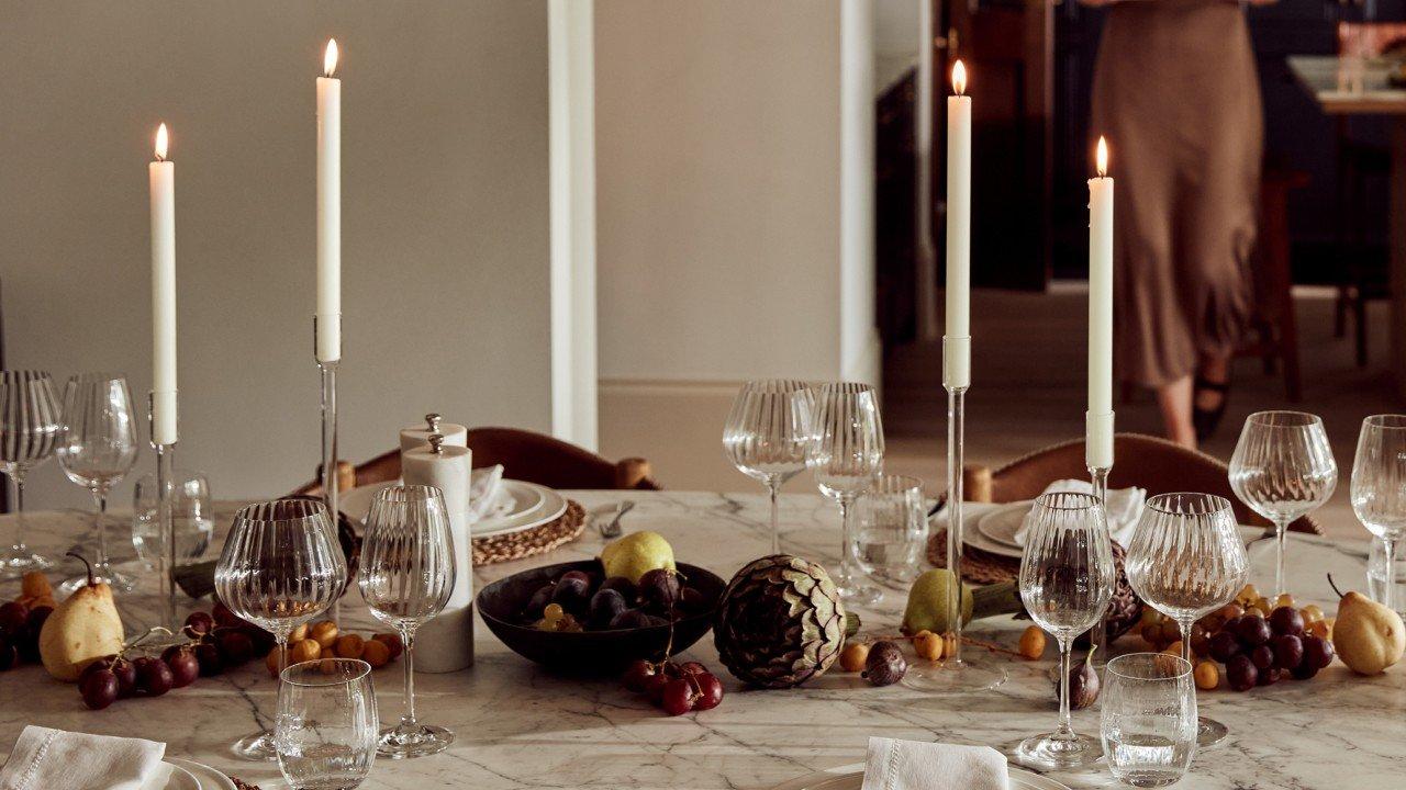 a table with a bunch of candles and some fruit on it