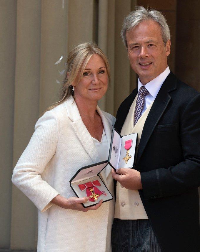 chrissie-rucker-holding-an-obe-award-with-husband